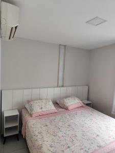 a bedroom with a bed with two pink pillows at AP Completo em Garanhuns vista avenida (104) in Garanhuns +18 photos
