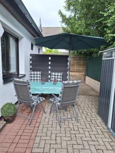 a table and two chairs and an umbrella on a patio at Ferienwohnung W.Esel in Wesel