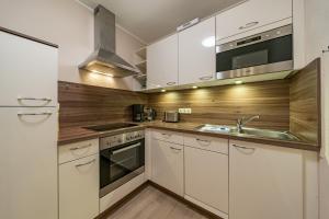 a kitchen with white cabinets and a sink at Haus Boje Haus Boje 3 in Schillig +7 photos