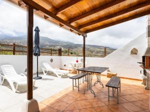 a patio with a table and chairs and an umbrella at Live Arico El Cortijo Casa Rural con Solarium y Terraza in Arico Viejo