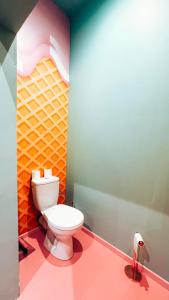 a bathroom with a toilet in a colorful room at Capsule Bonbon - Balneo - Sauna - Billard - Nintendo Switch in Douai +22 photos