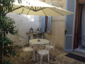 a table and chairs under an umbrella on a patio at Bordighera Castello Selva Dolce in Bordighera