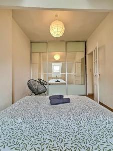 a bedroom with a bed and a table and a chair at WonderHost, spacieux et atypique en coeur de ville in Pau