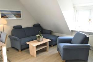a living room with two blue chairs and a table at Thora Jaiken Hüs Thora Jaiken, Apart Anneke in Rantum