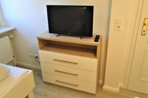 a tv on a dresser with a television on it at Thora Jaiken Hüs Thora Jaiken, Apart Anneke in Rantum