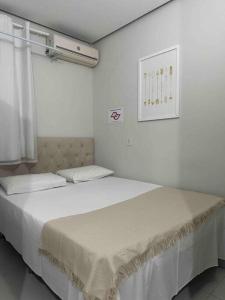 Postel nebo postele na pokoji v ubytování Kitnet 205 no centro com ar condiciona e tv smart