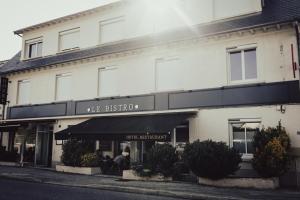 a white building with a sign for a store at Le BISTRO in Olemps