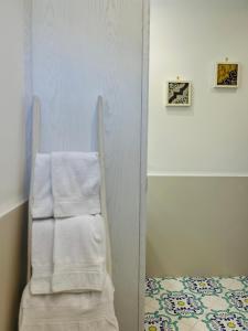 a towel rack with a pile of towels next to a bed at B&B L'Agapanto in Capri