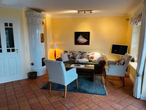 a living room with a couch and two chairs at Teil "Carpe Diem" in Rantum