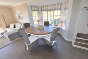 a living room with a wooden table and chairs at Landhaus auf der Düne, App 4 in Rantum +3 photos