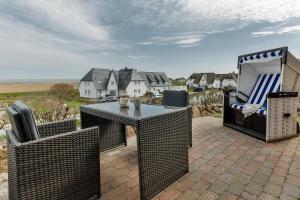 a patio with a table and chairs on a brick patio at Landhaus auf der Düne, App 2 in Rantum