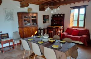 a living room with a table and a red couch at Camugnano farm in Rapolano Terme