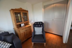 a living room with a chair and a cabinet at Friesenhof, fr 02 in Rantum