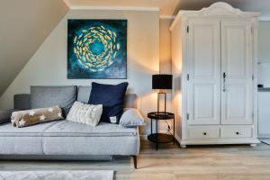 a living room with a couch and a painting at Heefkant Haus Heefkant - Apartment 08 in Rantum