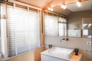 a bathroom with a white sink and a mirror at Strandhaus in Rantum +23 photos