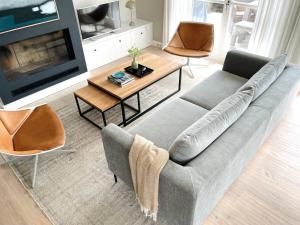 a living room with a couch and a table and a tv at Strandhaus in Rantum