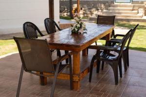 a wooden table with chairs and a vase of flowers on it at Cabañas brisas del mar in Puebloviejo
