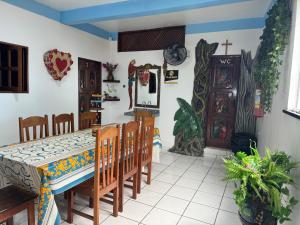 a dining room with a table and chairs and a cross on the wall at Pousada Vilasboas in Parintins