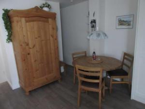 a dining room with a table and a wooden cabinet at Wattblick Haus Wattblick "Wattglück" in Rantum