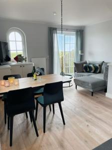 Una sala de estar con una mesa y sillas y un sofá. en Warfthüs, App 1, en Rantum