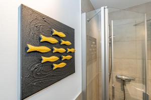 a bathroom with yellow shoes on the wall at Söl'ring Hüs "kleiner traum rantum" in Rantum +7 photos