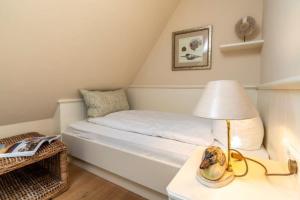 - une petite chambre avec un lit et une lampe sur une table dans l'établissement Godewind Haus Godewind, GO01, à Rantum