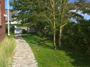 a tree on the side of a brick road at Marmelbloom in Rantum
