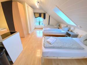a attic room with three beds and a staircase at V Apartment 4 Personen - Monteurzimmer - Ferienwohnung - Kronwieden in Loiching