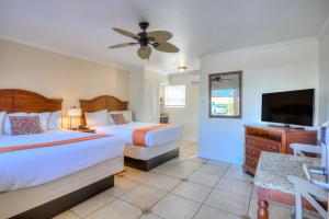 a bedroom with two beds and a flat screen tv at La Fiesta Ocean Inn & Suites in Saint Augustine Beach +60 photos