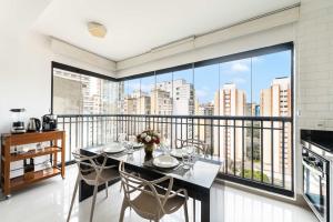 a dining room with a balcony with a table and chairs at Rosemari's Apartments SJ Urban Chic in Sao Paulo +282 photos