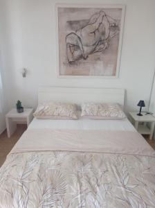 Una cama en un dormitorio con un cuadro en la pared. en Apartment Studio Antonia, en Medulin