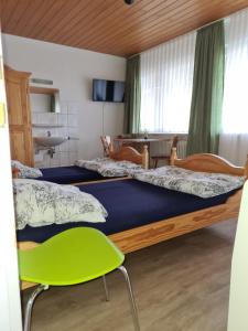 a bedroom with two beds and a green chair at Gemütliche Monteurunterkunft in Geislingen an der Steige