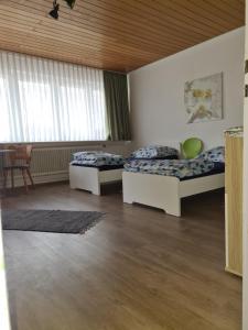 a bedroom with two beds and a table and chairs at Gemütliche Monteurunterkunft in Geislingen an der Steige +2 photos