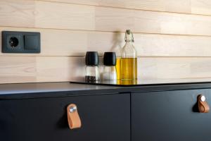 a bottle of oil sitting on top of a cabinet at Chic Sauna Cabin Near the Sea - SABIN Cabin Nº04 in Tsitre +25 photos