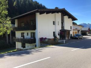 a large white building on the side of a street at Alpin Haus Klösterle in Wilden