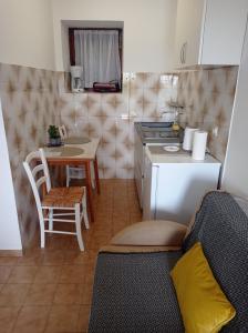Una pequeña cocina con una mesa pequeña y una cocina. en Apartment Studio Antonia, en Medulin