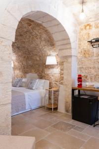 a bedroom with a bed in a stone wall at Atagio luxury room in Ostuni