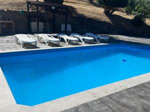 MuresにあるCortijo Wenceslao IIの青いスイミングプール(ラウンジチェア、ガゼボ付)
