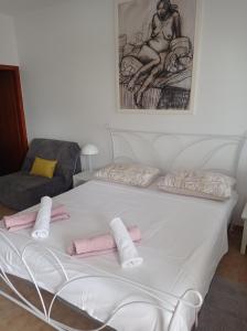 Una cama blanca con almohadas rosas encima. en Apartment Studio Antonia, en Medulin