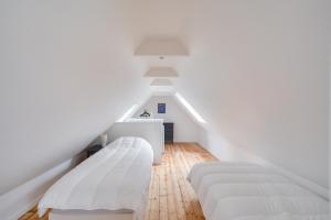 a white room with two beds and a staircase at Jolie maison à la campagne pour 4 in Saint-Jean-Trolimon