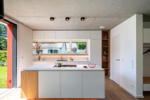 a kitchen with white cabinets and a window at Haus Riga in Prerow