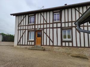 a black and white building with a orange door at Chez Suzanne Maison à la campagne 2-8pers 4 chambres in Longeville-sur-la-Laines