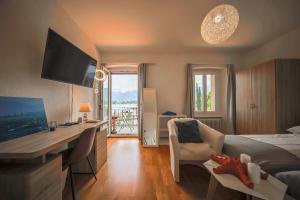 a hotel room with a bed and a desk with a television at Le Dock in Port-Valais