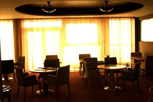 a dining room with tables and chairs and windows at Amber SPA Boutique Hotel in Jūrmala