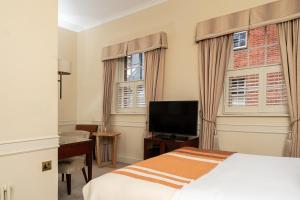 a bedroom with a bed and a flat screen tv at Royal Berkshire in Ascot