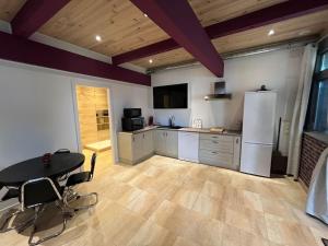 a large kitchen with a table and a refrigerator at Charmant 2 pièces in Gries