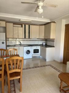 a kitchen with white appliances and a table and chairs at Ipanema 52 - La Manga By WATERMELON in La Manga del Mar Menor