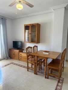 a dining room with a table and chairs and a tv at Ipanema 52 - La Manga By WATERMELON in La Manga del Mar Menor +15 photos