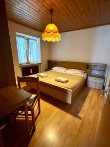 a bedroom with a large bed and a chandelier at Casa Defrancesco in Panchià