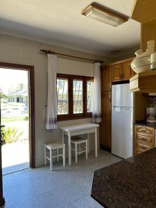 una cucina con un frigorifero bianco e un tavolo di CHALET - Vista al atardecer By WATERMELON a La Manga del Mar Menor
